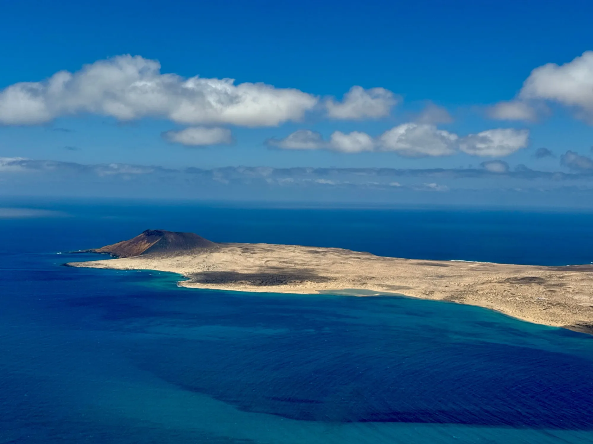 La Graciosa from the cliffs of Lanzarote, a pale island ringed by turquoise water